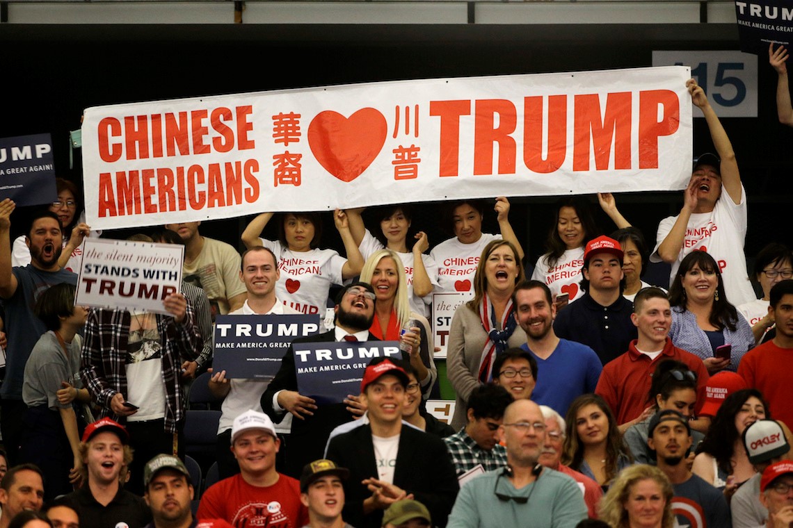 chinese americans holding up a we love trump sign