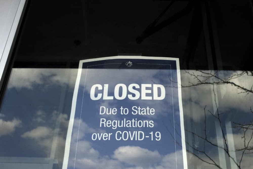 In this Wednesday, April 22, 2020 photo a closed sign is posted in the window of a store because of the coronavirus, in an outdoor mall, in Dedham, Mass. More than 4.4 million laid-off workers applied for U.S. unemployment benefits last week as job cuts escalated across an economy that remains all but shut down, the government said Thursday. (AP Photo/Steven Senne)